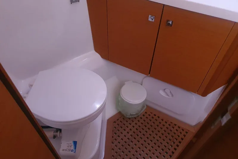  Yacht Photos Pics Bathroom interior of 2013 Jeanneau 57 yacht with wooden cabinets and toilet.