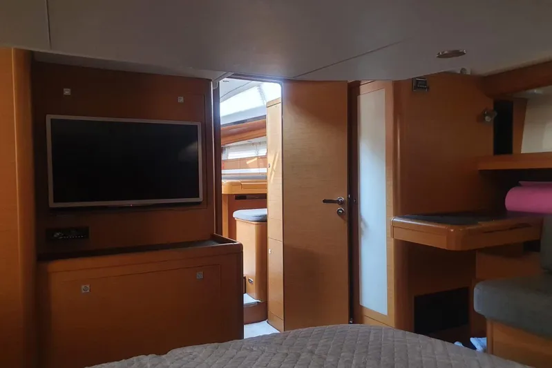  Yacht Photos Pics Interior of 2013 Jeanneau 57 yacht with TV, wooden cabinetry, and natural light.