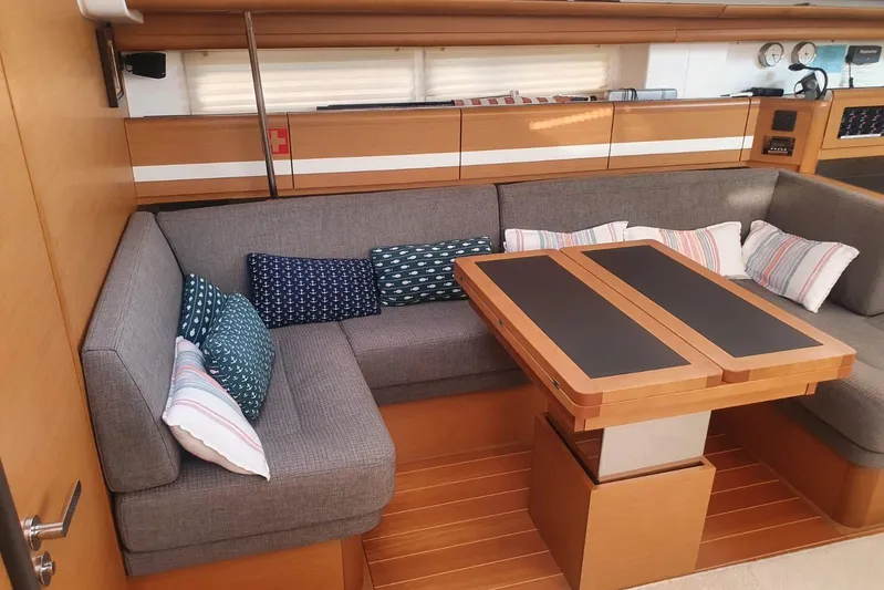  Yacht Photos Pics Luxurious interior of 2013 Jeanneau 57 yacht with cozy seating and elegant wooden table.