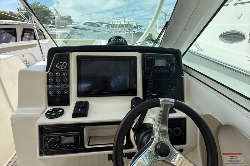  Yacht Photos Pics 2016 Sailfish 325 DC boat dashboard with steering wheel and navigation controls.