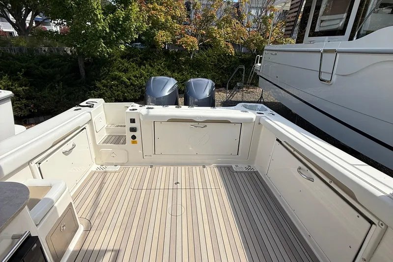  Yacht Photos Pics 2016 Sailfish 325 DC boat deck with twin engines, surrounded by greenery.