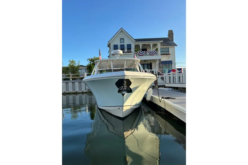  Yacht Photos Pics 2016 Sailfish 325 DC boat docked near a charming waterfront house.