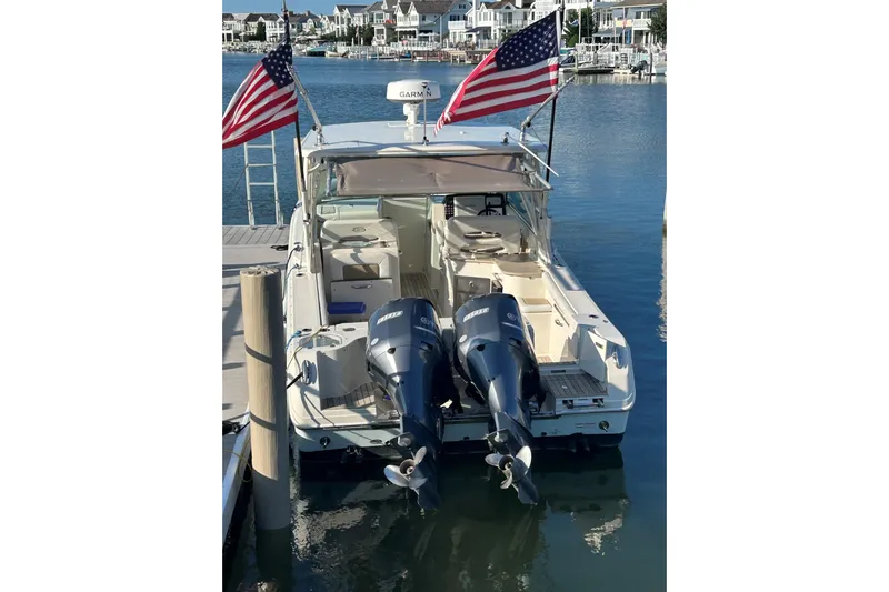  Yacht Photos Pics 2016 Sailfish 325 DC boat docked with twin outboard motors and American flags.
