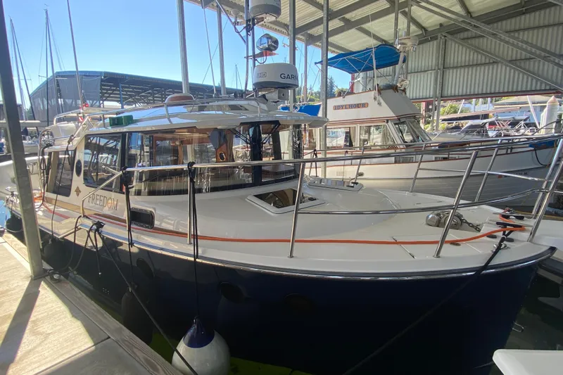  Yacht Photos Pics 2019 Ranger Tugs R-29 S docked in a marina under a covered shelter.