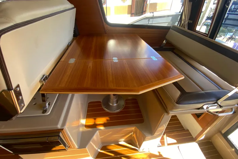  Yacht Photos Pics 2019 Ranger Tugs R-29 S interior with wooden table and cushioned seating.