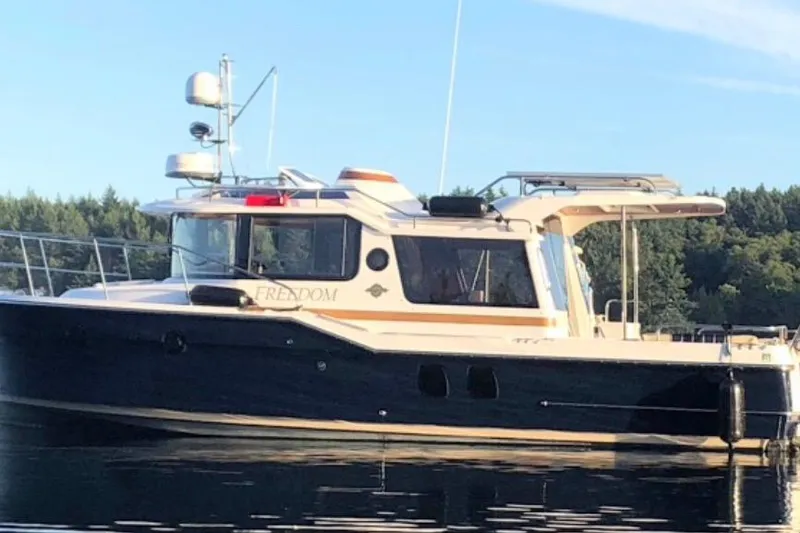  Yacht Photos Pics 2019 Ranger Tugs R-29 S boat on calm water, surrounded by trees.