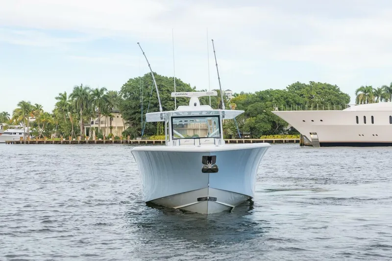 Rule #1 Yacht Photos Pics 2023 Yellowfin 42 Offshore boat on water, surrounded by palm trees and yachts.