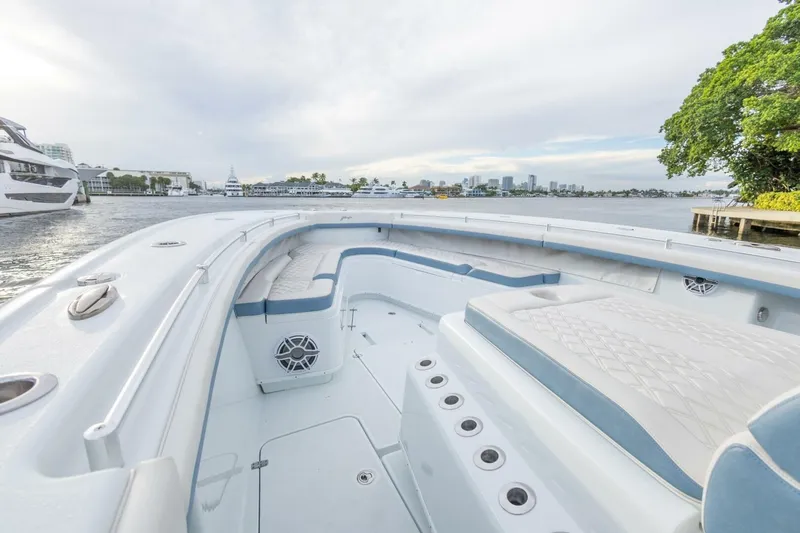 Rule #1 Yacht Photos Pics 2023 Yellowfin 42 Offshore boat interior with seating, on a calm waterfront.