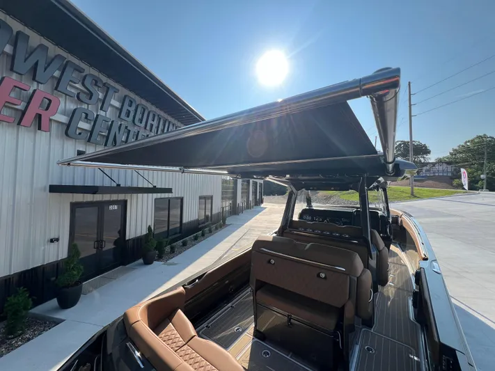  Yacht Photos Pics 2026 Nor-Tech 400 Supersport boat with sunshade, parked at a boating center under bright sunlight.