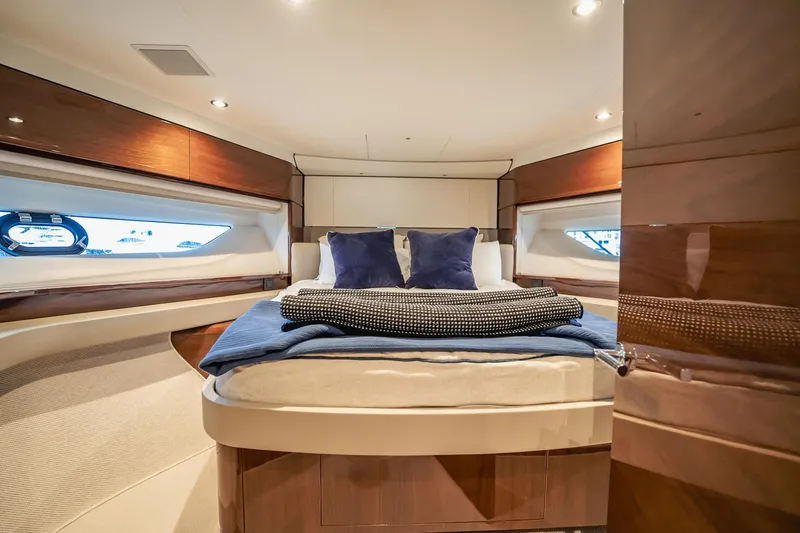 Endeavor Yacht Photos Pics Luxurious cabin interior of 2019 Princess F55 yacht with elegant bedding and wood finishes.