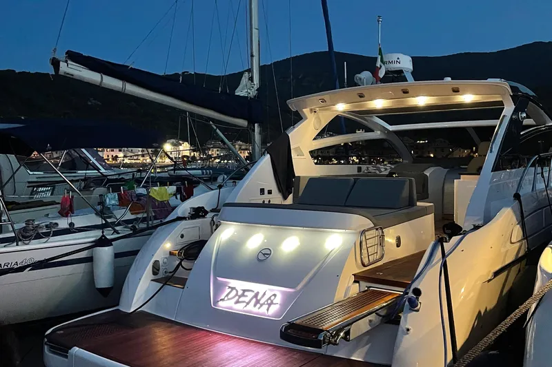 Dena Yacht Photos Pics Luxury Airon Cinquanta 50 yacht docked at night, illuminated with ambient lights.