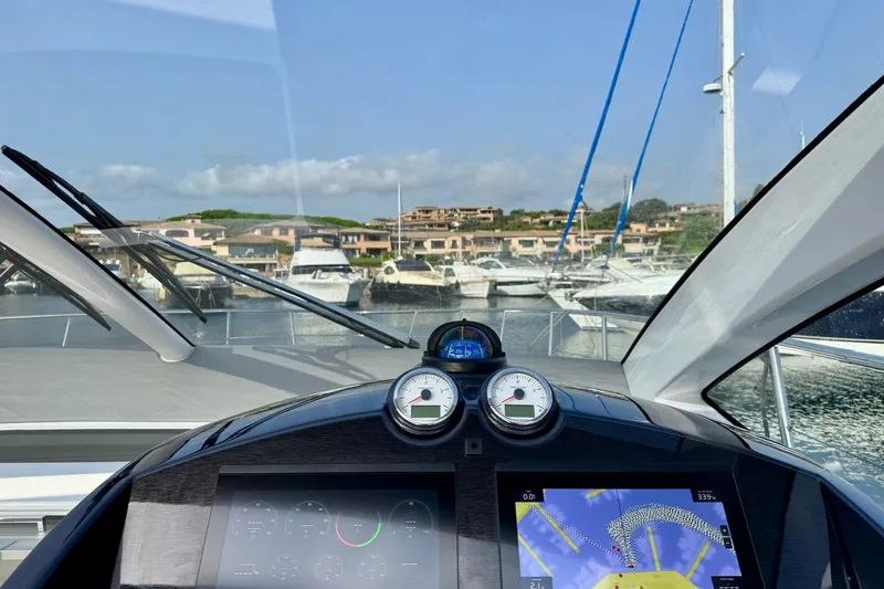 Dena Yacht Photos Pics Cockpit view of 2021 Airon Cinquanta 50 yacht, featuring navigation instruments and marina backdrop.