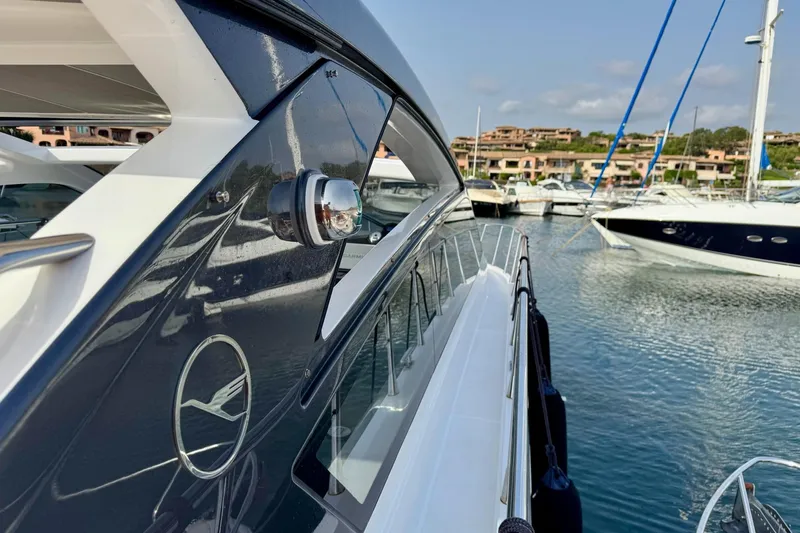 Dena Yacht Photos Pics 2021 Airon Cinquanta 50 yacht docked in a marina, showcasing sleek design and luxury.