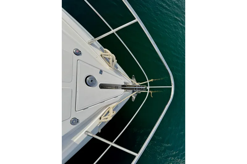 Dena Yacht Photos Pics Bow of 2021 Airon Cinquanta 50 yacht with anchor, surrounded by calm water.