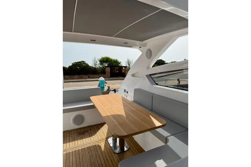 Dena Yacht Photos Pics Interior of 2021 Airon Cinquanta 50 yacht with wooden table and seating area.