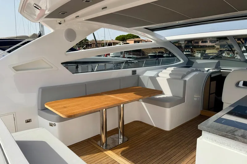 Dena Yacht Photos Pics Luxurious 2021 Airon Cinquanta 50 yacht interior with sleek seating and wooden table.