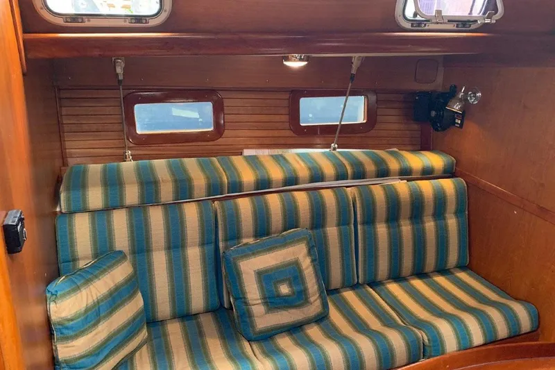 Tumblehome Yacht Photos Pics 1995 Little Harbor 51 Pilothouse interior with striped seating and wooden paneling.