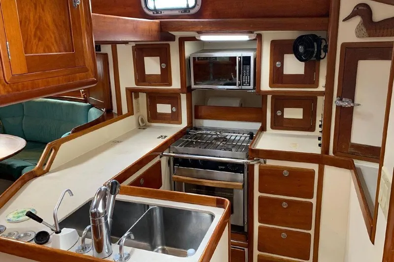 Tumblehome Yacht Photos Pics 1995 Little Harbor 51 Pilothouse yacht kitchen with wood cabinetry and modern appliances.