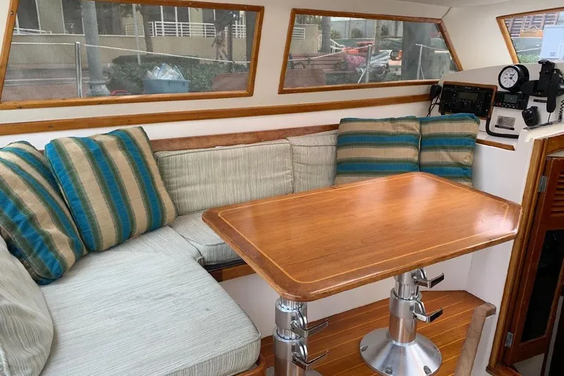 Tumblehome Yacht Photos Pics Cozy interior of 1995 Little Harbor 51 Pilothouse with cushioned seating and wooden table.