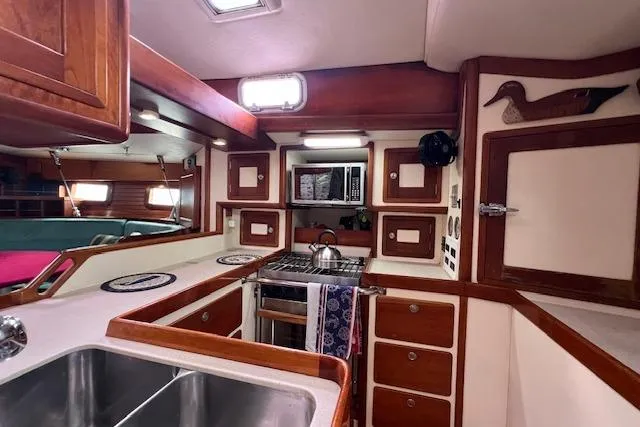 Tumblehome Yacht Photos Pics 1995 Little Harbor 51 Pilothouse yacht kitchen with wood cabinetry and stainless steel sink.