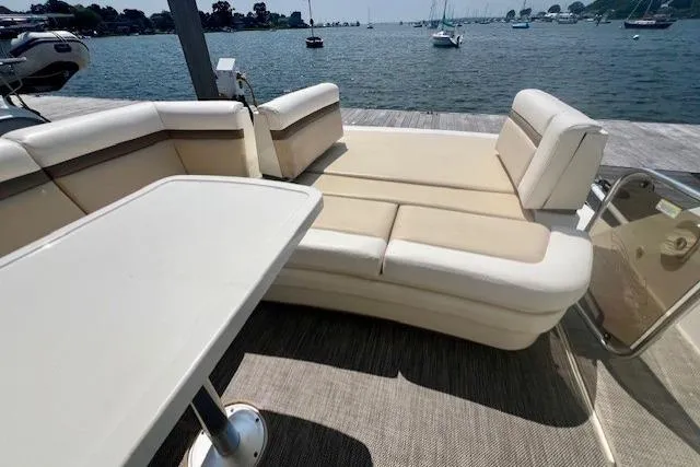 Stay Loose Yacht Photos Pics Luxurious 2013 Sea Ray 410 Sundancer yacht interior with beige seating and table, docked by the water.