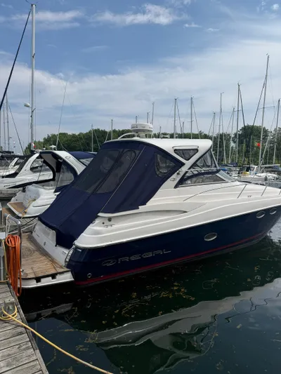  Yacht Photos Pics 2014 Regal 38 Express yacht docked at marina, featuring sleek design and blue canopy.