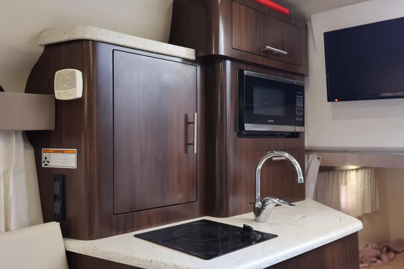  Yacht Photos Pics 2018 Regal 28 Express boat interior kitchen with microwave, sink, and TV.