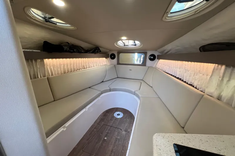  Yacht Photos Pics 2018 Regal 28 Express cabin interior with beige seating and wood flooring.