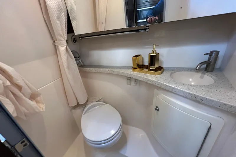  Yacht Photos Pics 2018 Regal 28 Express boat bathroom with sink, toilet, and gold accessories.