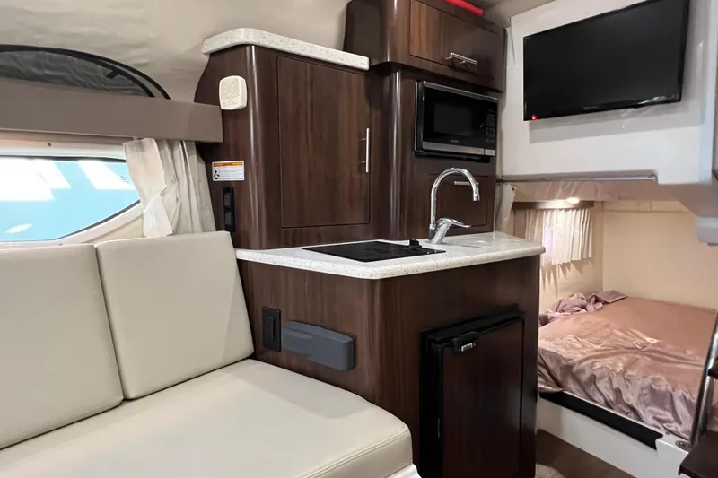  Yacht Photos Pics 2018 Regal 28 Express interior with kitchenette, seating, and sleeping area.