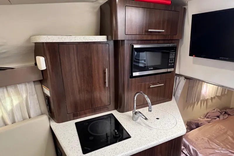  Yacht Photos Pics 2018 Regal 28 Express boat interior with kitchenette, microwave, and TV.