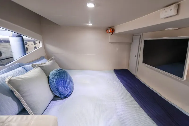  Yacht Photos Pics Luxurious interior cabin of 2021 Evolve 400HT yacht with cozy bedding and modern TV.
