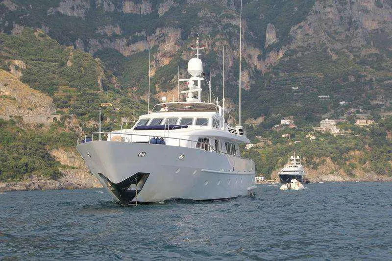  Yacht Photos Pics Codecasa 32m yacht from 1999 cruising near a scenic coastal landscape.