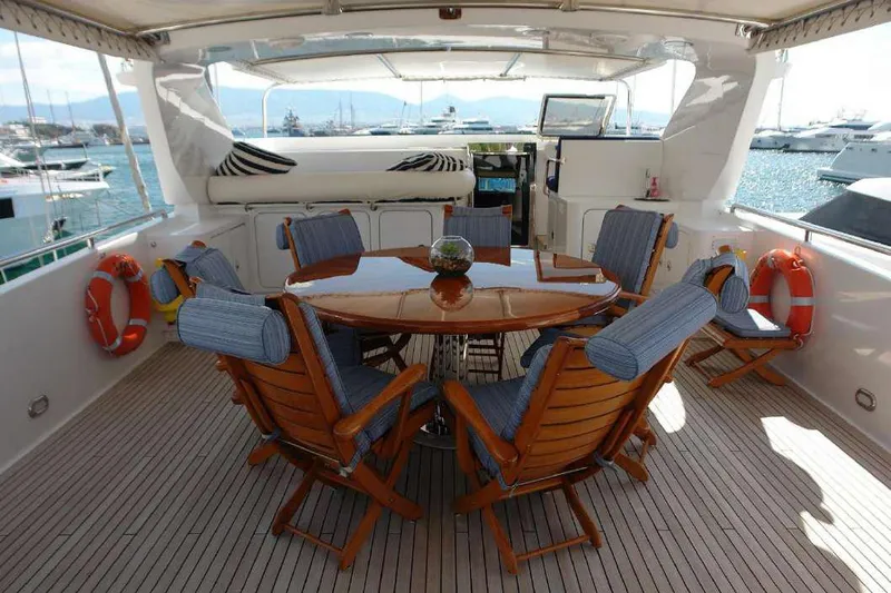  Yacht Photos Pics Codecasa 32m 1999 yacht deck with wooden dining table and chairs.