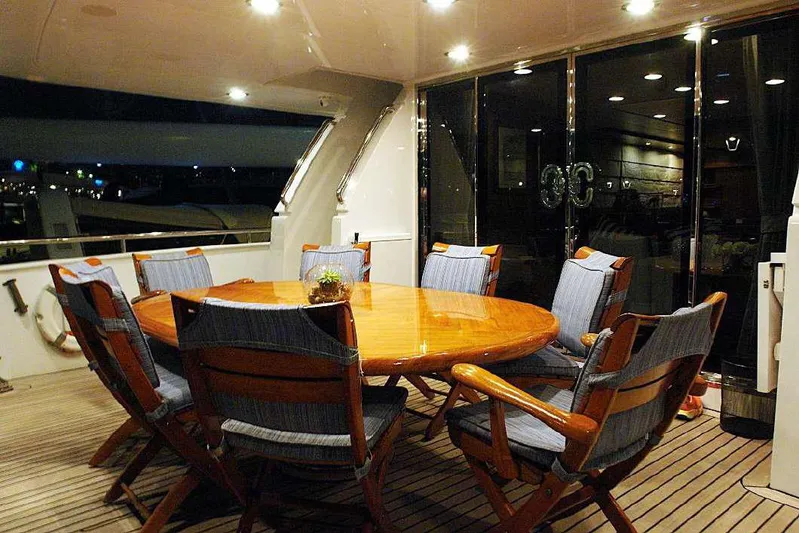  Yacht Photos Pics Luxurious dining area on a 1999 Codecasa 32m yacht with wooden table and cushioned chairs.