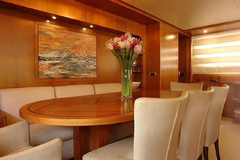  Yacht Photos Pics Elegant dining area on a 1999 Codecasa 32m yacht with wooden table and floral centerpiece.