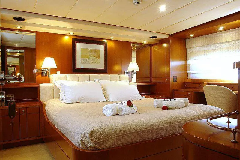  Yacht Photos Pics Luxurious bedroom on a 1999 Codecasa 32m yacht with elegant wooden interiors.