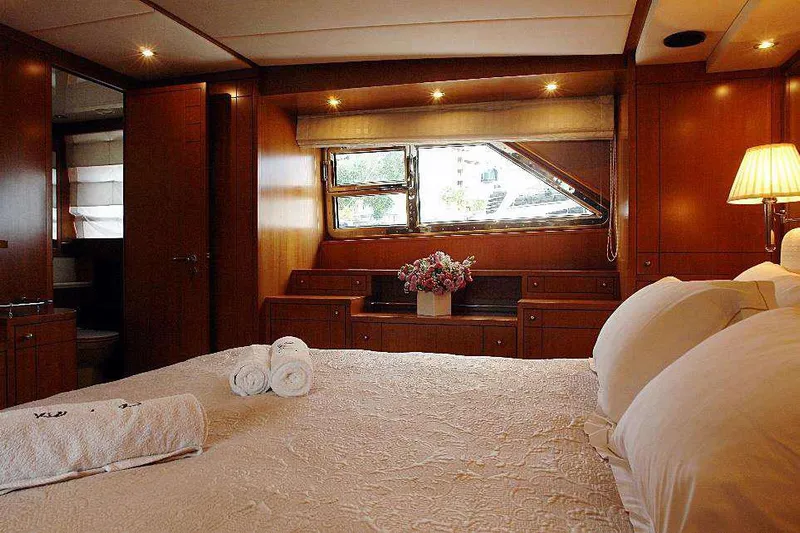  Yacht Photos Pics Luxurious bedroom on a 1999 Codecasa 32m yacht with wooden interiors and cozy lighting.