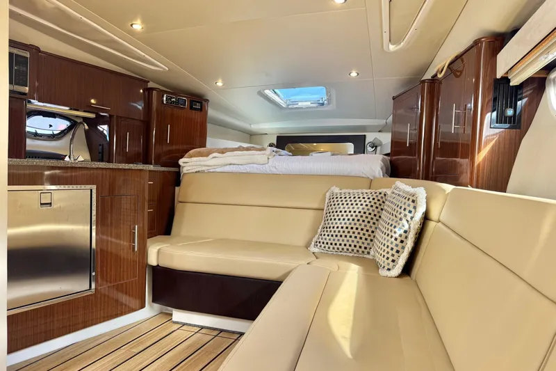  Yacht Photos Pics Luxurious interior of 2013 Regal 35 Sport Coupe with beige seating and wood cabinetry.