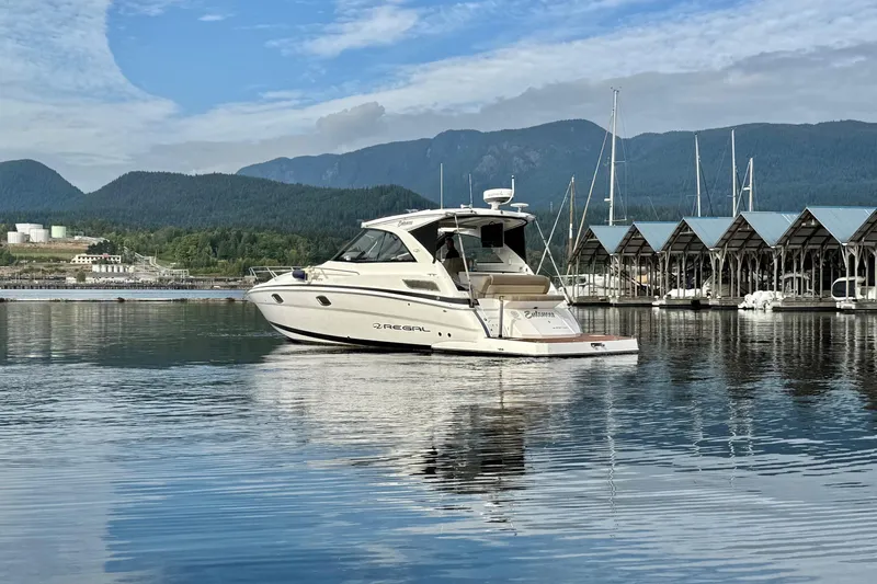  Yacht Photos Pics 2013 Regal 35 Sport Coupe yacht on calm water near marina, mountains in background.