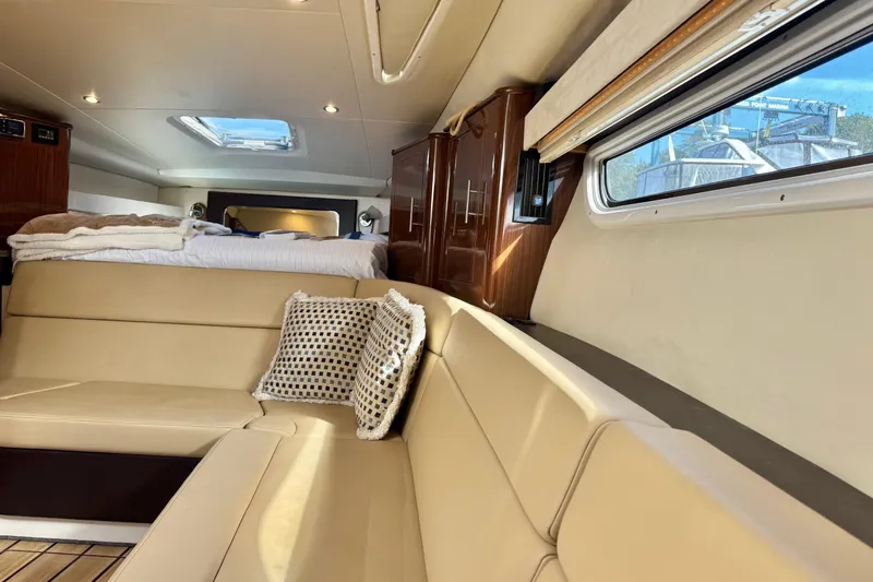  Yacht Photos Pics Interior of 2013 Regal 35 Sport Coupe with beige seating and cozy bedding.