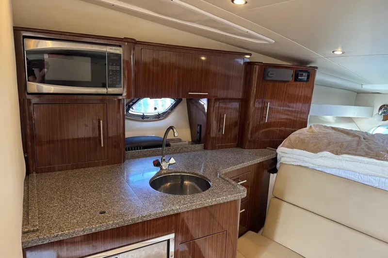  Yacht Photos Pics 2013 Regal 35 Sport Coupe interior with kitchenette, featuring wood cabinets and granite countertop.