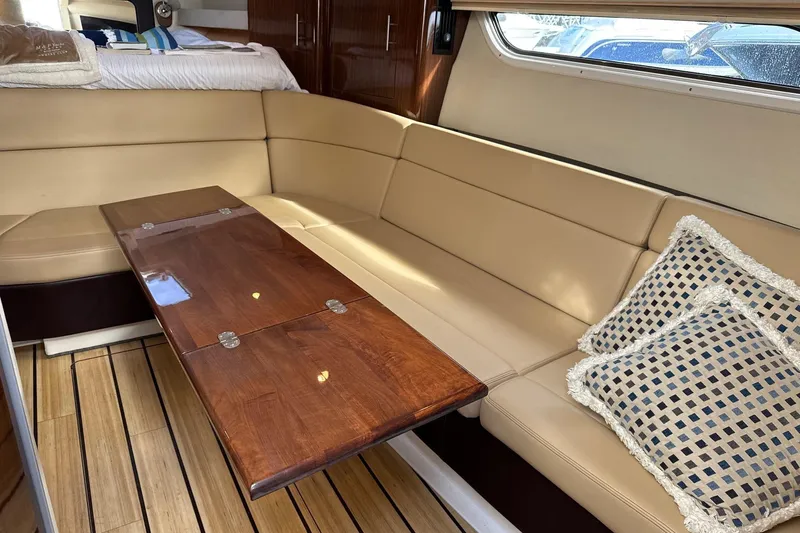  Yacht Photos Pics Luxurious interior of 2013 Regal 35 Sport Coupe with beige seating and wooden table.