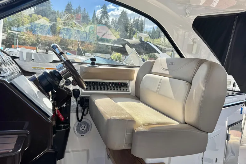  Yacht Photos Pics Interior of 2013 Regal 35 Sport Coupe with steering wheel and beige seating.