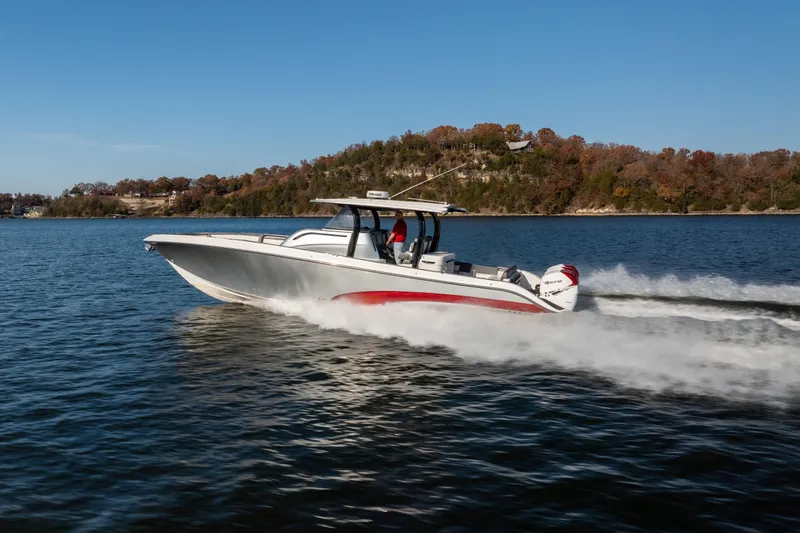  Yacht Photos Pics 2020 Fountain 43 NX boat cruising on a lake with scenic autumn backdrop.
