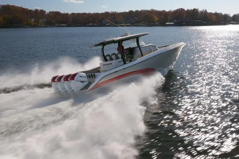  Yacht Photos Pics 2020 Fountain 43 NX speedboat cruising on a sunny lake with powerful engines.