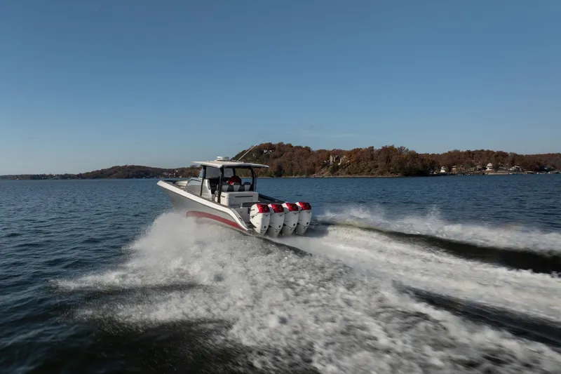  Yacht Photos Pics 2020 Fountain 43 NX boat speeding on a lake with four engines, scenic background.