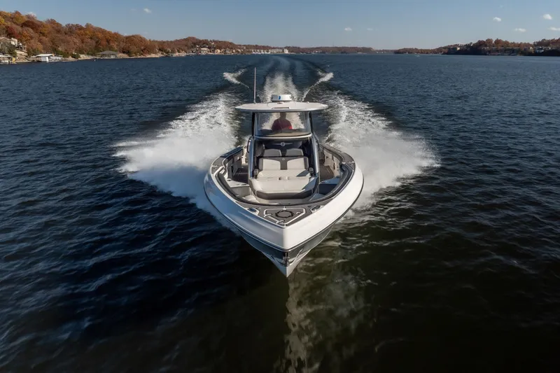 Yacht Photos Pics 2020 Fountain 43 NX boat cruising on a scenic lake with autumn foliage.