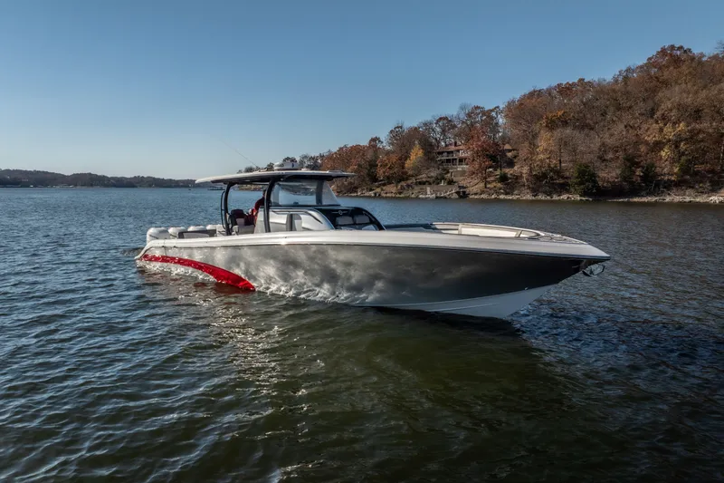  Yacht Photos Pics 2020 Fountain 43 NX boat cruising on a lake with autumn trees in the background.