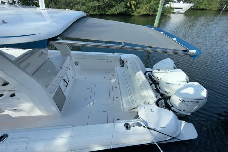  Yacht Photos Pics 2022 Intrepid 407 Panacea boat with triple outboard engines, docked on calm water.